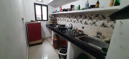 菩提伽耶Kalawati Niwas的厨房配有水槽和红色冰箱