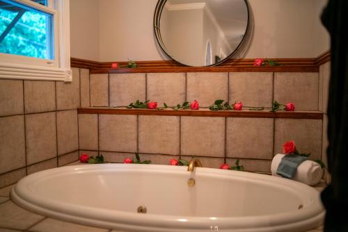 尤里卡斯普林斯Inn at Rose Hall的浴室配有浴缸及镜子