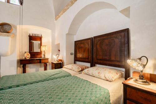 卡斯特里尼亚诺德尔卡波Antica corte dell'800的一间卧室配有两张床和一张桌子上的台灯。