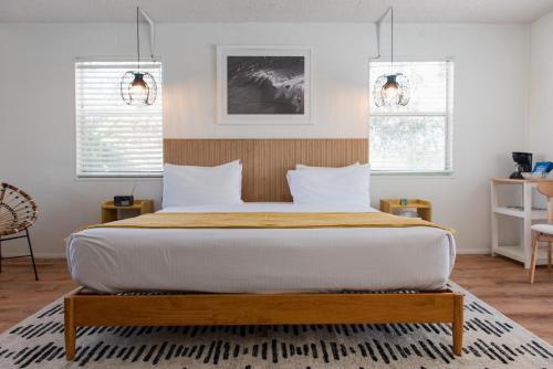 维洛海滩Seaspray Surf Lodge的一间卧室设有一张大床和两个窗户。