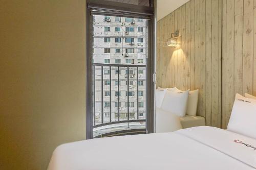 首尔HERTZ Hotel的酒店客房设有床和窗户。