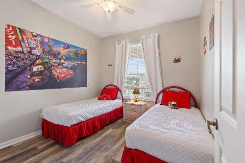 基西米Mickey's Whimsical Wonderland的一间卧室设有两张床,墙上挂着一幅画