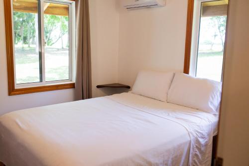 奥兰治沃克Crystal Creek Lodge的带2扇窗户的客房内的一张白色床