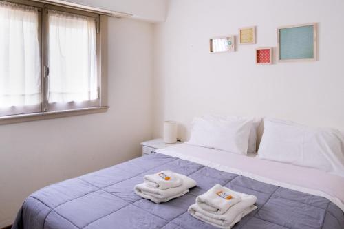 马德普拉塔Casa Nanet Hotel的一间白色卧室,床上配有2条毛巾