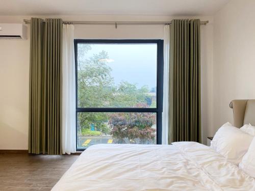 振林山Forest City Golf Course Resort Villa by Lions Bay的一间卧室设有一张床和一个大窗户