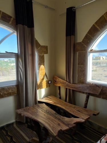 锡瓦People to People Hostel Siwa的客房设有木桌和2扇窗户。