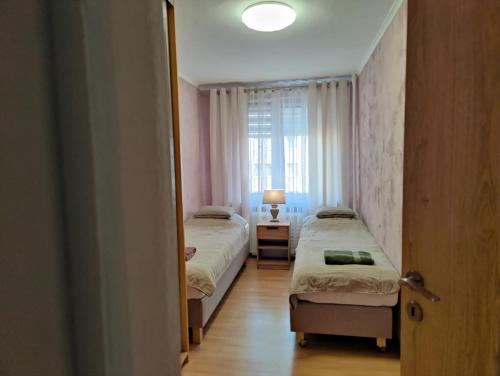 马佐夫舍地区新庄园Dwupokojowe mieszkanie Nowy Dwór Mazowiecki的一间卧室设有两张床和窗户。