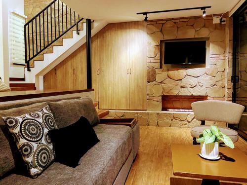 萨迈帕塔La Vista - Un lugar de Ensueño的带沙发和石墙的客厅