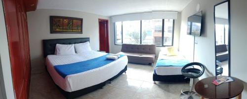 波哥大AG精品酒店的一间卧室配有一张床和一张沙发