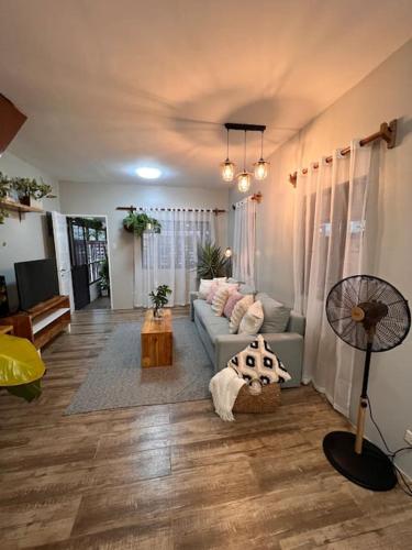 公主港Casa Privado- 2 Bedroom House Near the Airport的带沙发和风扇的客厅