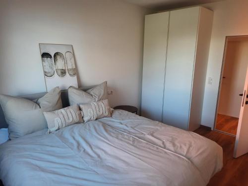 因斯布鲁克Apartment by Bruno的卧室配有一张带白色床单和枕头的大床。