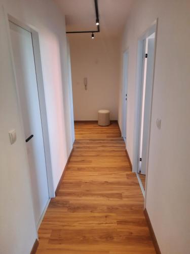 因斯布鲁克Apartment by Bruno的空的走廊,有白色的墙壁和木地板