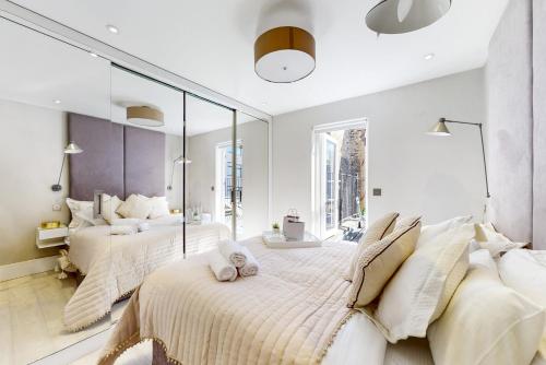 伦敦Park Lane Apartments Marylebone的一间卧室设有两张床和大镜子