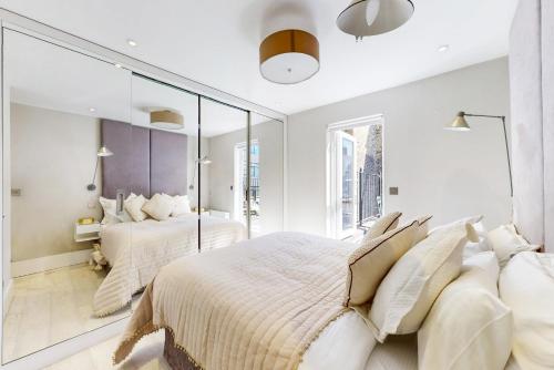 伦敦Park Lane Apartments Marylebone的一间卧室设有两张床和大镜子