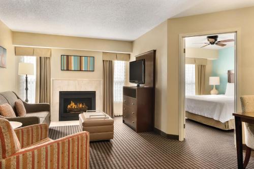 大急流城大瀑布城霍姆伍德套房酒店的酒店客房设有壁炉和一张床。