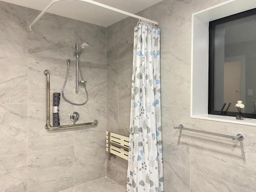 奥克兰Ali Motel的带淋浴和浴帘的浴室