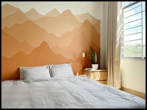 Trà VinhVilabasi Cổ Tháp的卧室配有一张挂有山壁画的床。