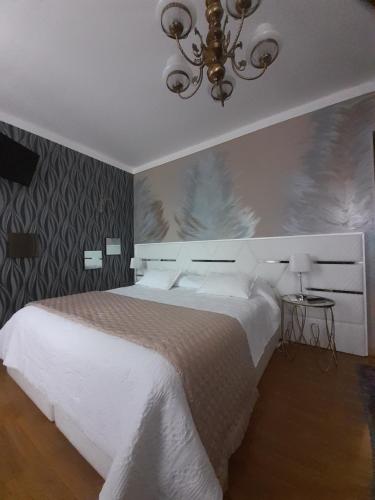 福什科阿新镇A Flor da Rosa的卧室配有白色的床和吊灯。
