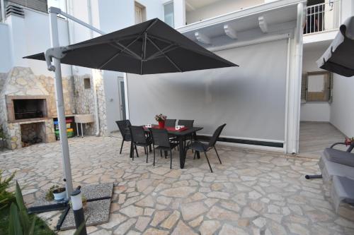 莱切Casa Romeo的庭院配有桌椅和遮阳伞。