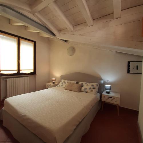 萨罗Loft trabucco panoramico 4 camere 7posti letto vista lago e centro storico的卧室设有一张白色大床和两个窗户。