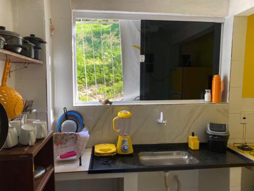 巴伊亚福尔莫萨Suítes Verano的带水槽的厨房台面和窗户