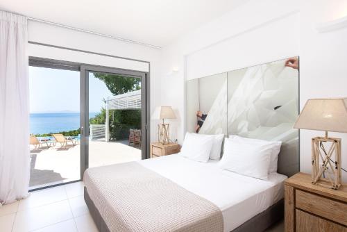 斯卡费迪亚爱奥尼亚马雷代套房度假酒店的一间卧室配有一张床,享有海景
