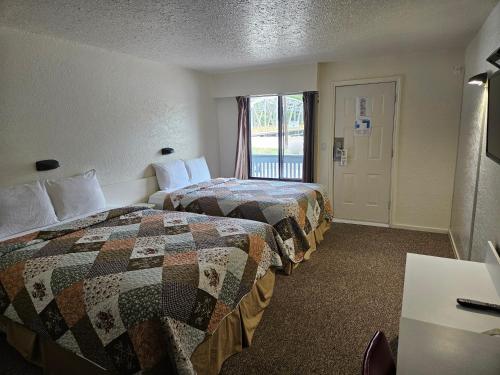大福克斯Granby River Inn & Suites的酒店客房设有两张床和窗户。