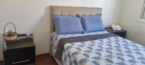 佩洛塔斯Casa Familiar Moradas Pelotas的一间卧室配有一张带蓝色和白色棉被的床
