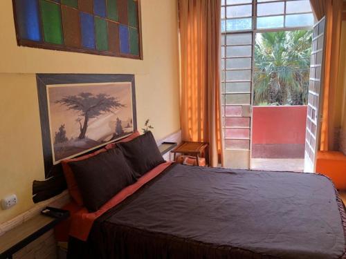 伊察瓦卡奇纳夕阳旅馆的一间卧室设有一张大床和一个窗户。