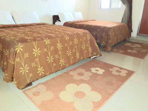 科纳克里Hotel du Golfe de Guinee的配有两张床的客房,地板上设有两张地毯