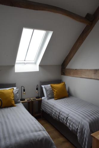 阿伯加文尼Cowshed in the Black Mountains的阁楼卧室设有两张床和天窗