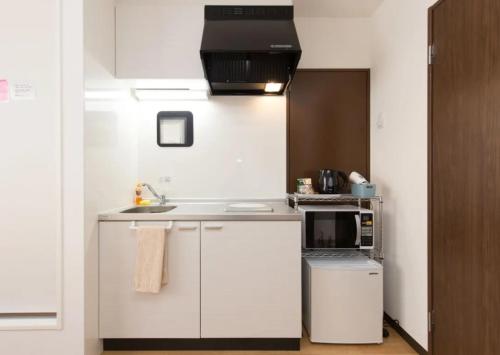 大阪HOTEL LUCKY - Vacation STAY 49954v的白色的厨房配有水槽和微波炉