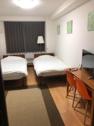 大阪HOTEL LUCKY - Vacation STAY 49954v的客房设有两张床和一张带电脑的书桌