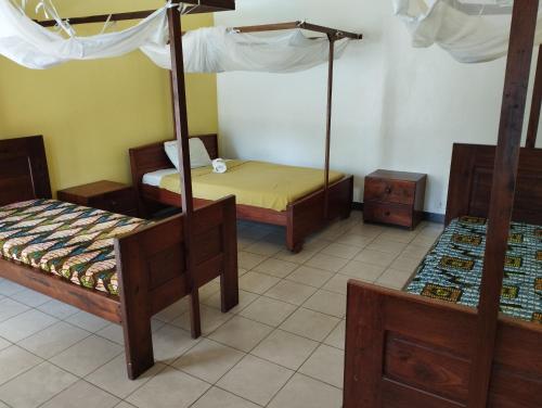 达累斯萨拉姆Cefa Hostel的客房设有两张床和一张天蓬床。