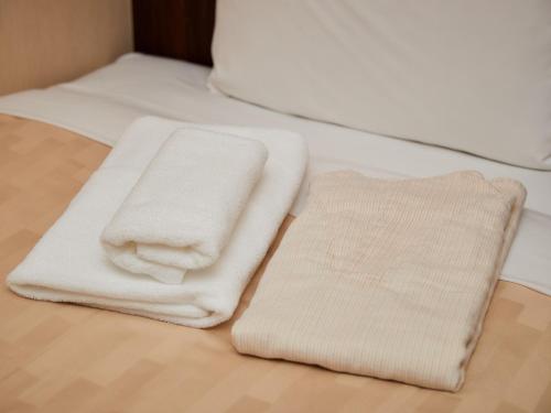 那霸Grand Cabin Hotel Naha Oroku - Vacation STAY 46864v的两条毛巾位于木地板上