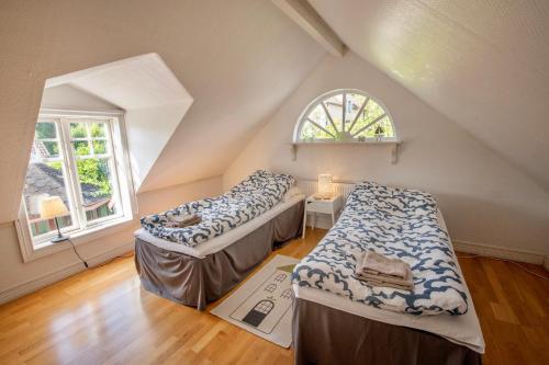 龙讷比Modern house in Ronneby near lake and sea的阁楼间 - 带两张床和窗户