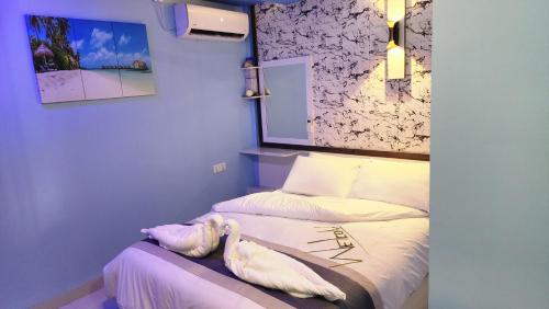 FuvahmulahIsle inn的一间卧室配有两张带白色床单的床