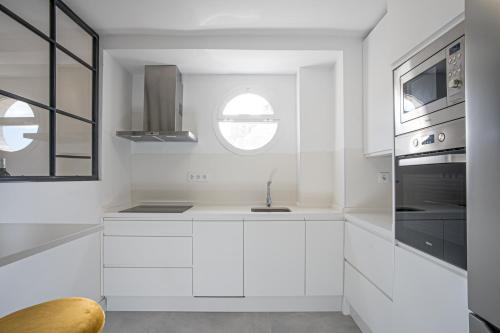 塞维利亚Luxury Apartment Free Parking的白色的厨房设有水槽和窗户