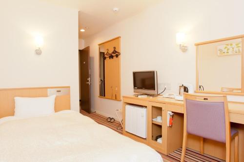 奈良Hotel Hanakomichi - Vacation STAY 27567v的酒店客房配有一张床、一张书桌和一台电视。