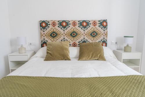 塞维利亚Luxury Apartment Free Parking的卧室配有带枕头的大型白色床