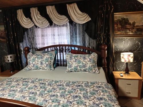 GarešnicaApartmani Jozić的卧室配有带枕头的木床和窗户。