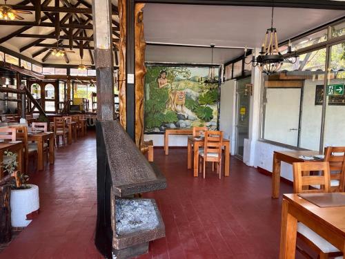 圣何塞德迈波Restaurant y Hostería El Tucán的一间带木桌和椅子的餐厅以及壁画