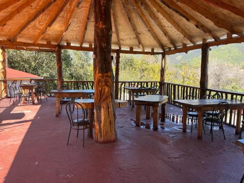 圣何塞德迈波Restaurant y Hostería El Tucán的屋顶下设有桌椅的木制凉亭