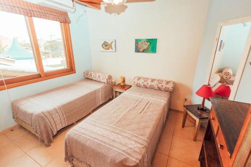 伊比拉奎拉Acomodações Ibirawave的客房设有两张床、一台电视和一扇窗户。