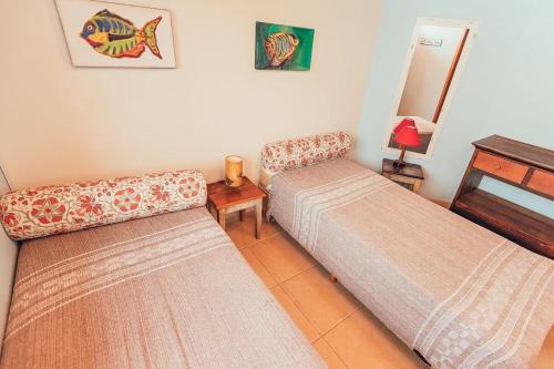 伊比拉奎拉Acomodações Ibirawave的一间设有两张床和一张桌子的房间