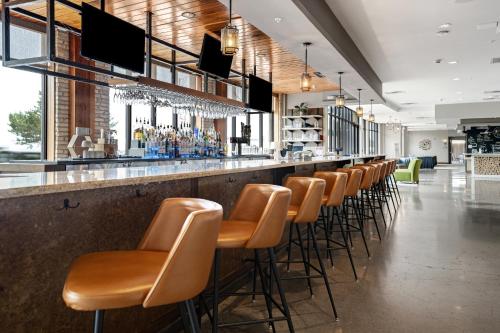 特拉弗斯城特拉弗斯城英迪格酒店的酒吧,酒吧里有一排棕色的酒吧凳