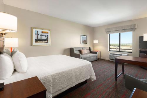 格伦代尔汉普顿酒店及套房－凤凰城格伦代尔－梅龙镇的酒店客房配有一张床、一张桌子和一把椅子。