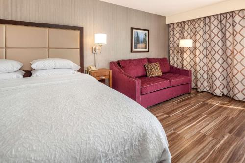 林伍德西雅图北部/林恩伍德汉普顿套房酒店 的酒店客房,配有一张床和一张红色的沙发