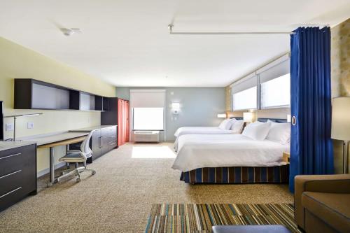 奥斯威戈奥斯威戈希尔顿欣庭套房酒店的酒店客房配有两张床和一张书桌