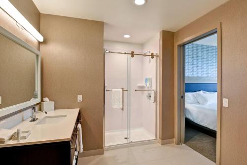 帕姆代尔棕榈谷希尔顿欣庭套房酒店的带淋浴和盥洗盆的浴室以及1张床。